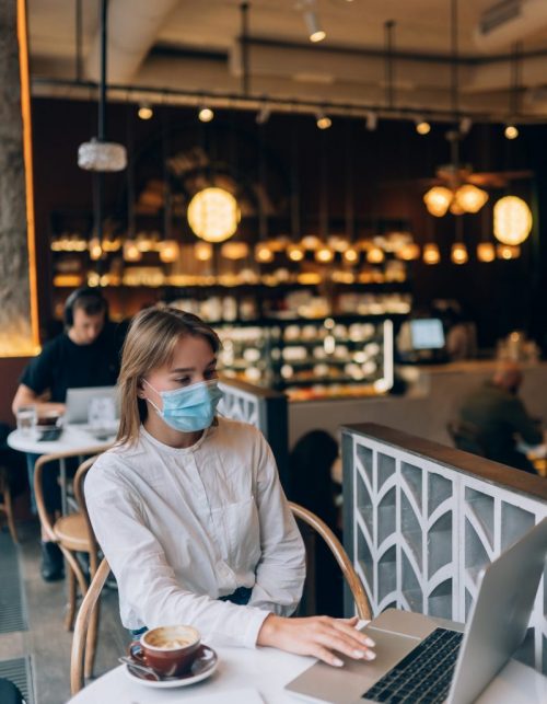 Pretty woman wearing medical face mask, using laptop to work. New Normal lifestyle, working happily together during quarantine as Coronavirus ,Covid-19